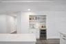 Virtually staged wet bar in place of pantry, water available on this wall