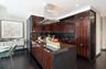 Kitchen featuring dark hardwood / wood-style floors, sink, island range hood, and dark brown cabinetry