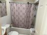 Bathroom featuring vanity, tile walls, shower / tub combo, and tile patterned flooring