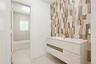 Bathroom with vanity, shower combination, light tile patterned floors, and tile walls
