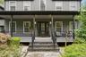 Inviting covered front porch with dark railing and columns