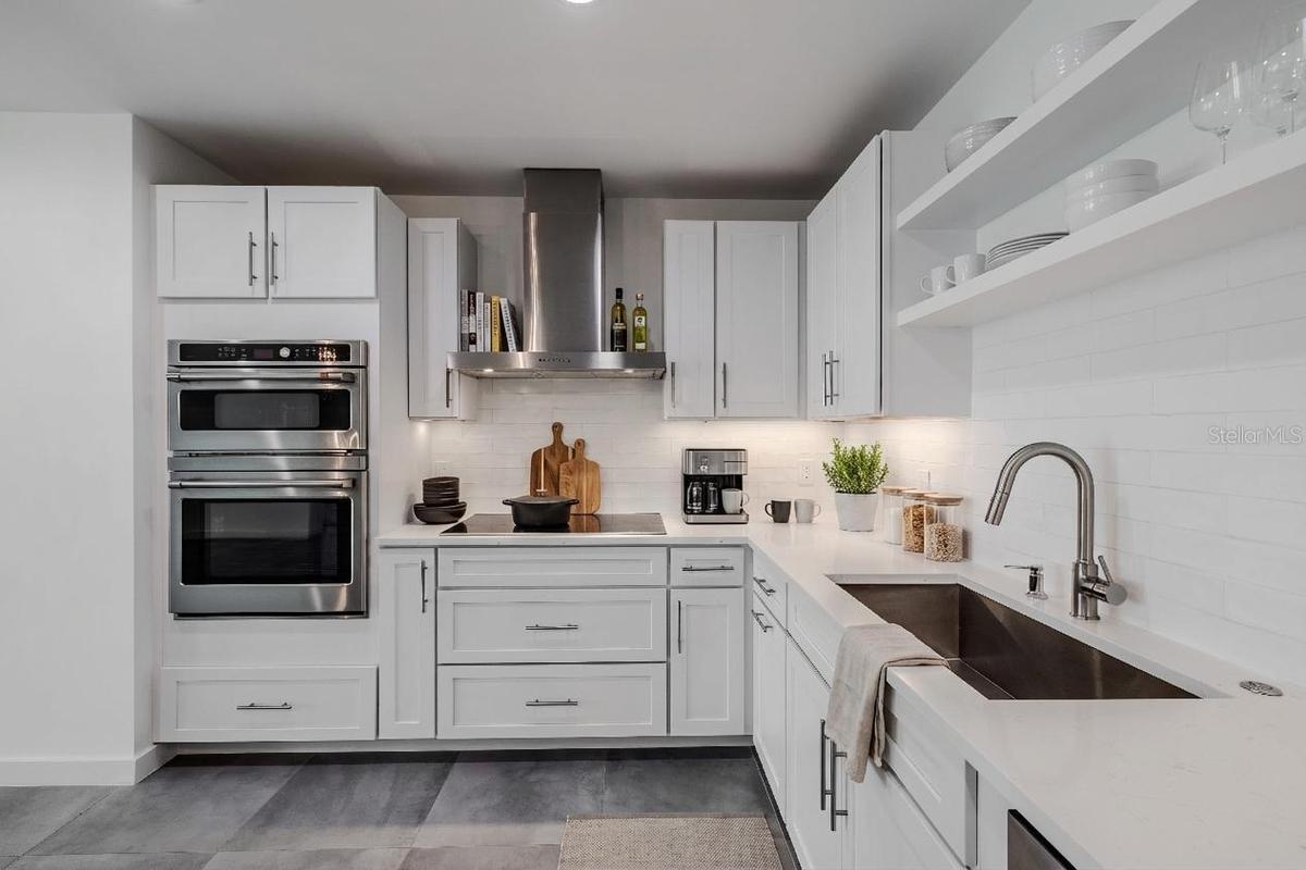 High-end stainless-steel appliances include a French door refrigerator, dishwasher, double wall ovens, and a vent hood. Large tile floors and under-c