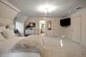 Carpeted bedroom featuring ensuite bath and crown molding