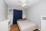 Room featuring light gray walls, white wainscoting, and wood-finish flooring