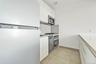 Kitchen featuring stainless steel appliances, white cabinets, and light countertops