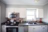 Kitchen featuring appliances with stainless steel finishes, dark countertops, and white cabinetry