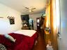 Bedroom featuring dark wood-type flooring, ornamental molding, and ceiling fan