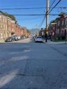 View of asphalt road with sidewalks, street lights, a residential view, and curbs