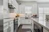 Kitchen with quartz countertops and steel farmhouse sink
