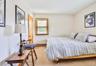Bedroom featuring light carpet and baseboard heating
