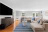 Living area featuring ornamental molding, light wood-style floors, recessed lighting, a decorative wall, and wainscoting
