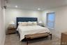 Bedroom with a wall unit AC, recessed lighting, and wood finished floors