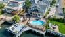 Aerial perspective of suburban area with a pool and a large body of water