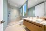 Bathroom with a shower stall, vanity, tile walls, and recessed lighting