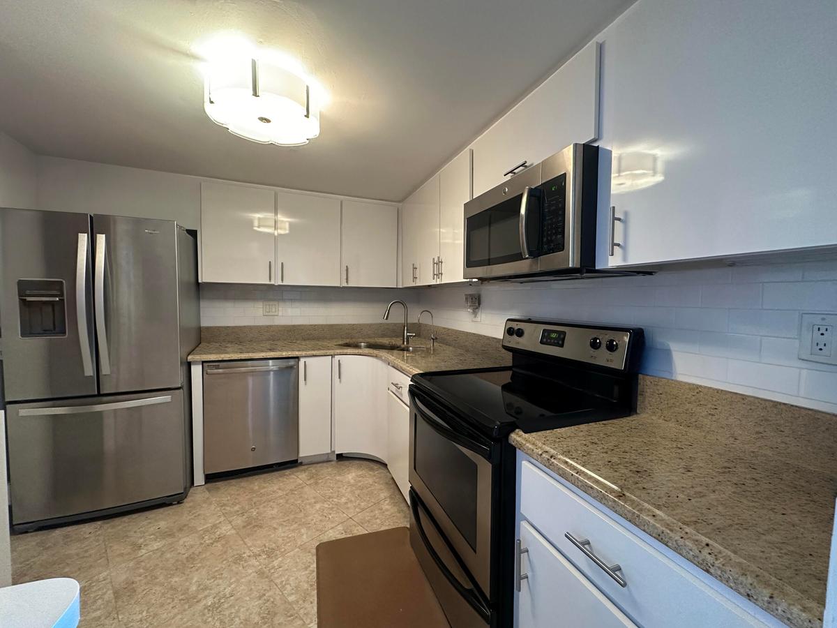 Bright white cabinetry and stainless appliances create a clean, coastal feel, effortless and welcoming