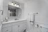 Full bath with vanity, toilet, a stall shower, and wainscoting