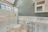 Bathroom featuring tile patterned floors, sink, a shower with door, and toilet