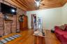 Living room featuring ceiling fan, ornamental molding, brick wall, and wood-type flooring