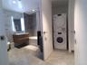 Bathroom featuring light marble finish floors, vanity, a combined bath / shower with marble appearance, estacked washer and dryer, and recessed lighti