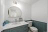 Half bath with a wainscoted wall, toilet, and vanity