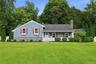 Single-story residence featuring blue cedar shingles , white trim, and red shutters