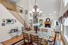 Dining room with a towering ceiling, a glass covered fireplace, stairs, light wood finished floors, and recessed lighting