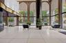 Spacious lobby featuring polished tiled flooring, floor-to-ceiling arched windows, and a prominent dark architectural column
