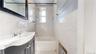 Full bathroom featuring tile walls, vanity, radiator, and shower / bathtub combination