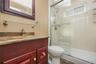 Wood-finish vanity with a stone countertop and an integrated sink