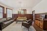 Living area with a wainscoted wall, dark wood finished floors, a chandelier, healthy amount of natural light, and radiator heating unit
