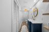 Renovated bath with herringbone white subway tile, a custom navy vanity, white marble counter, brass fixtures, and a walk-in marble shower.