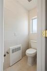 Bathroom featuring light tile patterned floors, tile walls, and heating unit