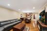 Open-concept living area with wood-finish flooring, recessed lighting, and crown molding