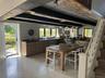 Dining room featuring stairway, beam ceiling, finished concrete flooring, and wooden walls
