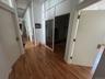 Hallway featuring wood finished floors and a towering ceiling