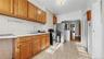 Kitchen with brown cabinetry, black gas range, light countertops, and arched walkways