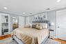 Primary bedroom featuring recessed lighting, light wood-type flooring, ornamental molding, and ensuite bathroom