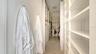 Spacious primary suite closet with custom built-in shelving for organization and style