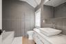 Bathroom featuring tile walls, vanity, a bath, and lofted ceiling