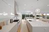Kitchen featuring white cabinets, a healthy amount of sunlight, a spacious island, and sink