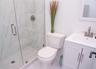 Bathroom featuring a marble finish shower, vanity, and marble look tile flooring
