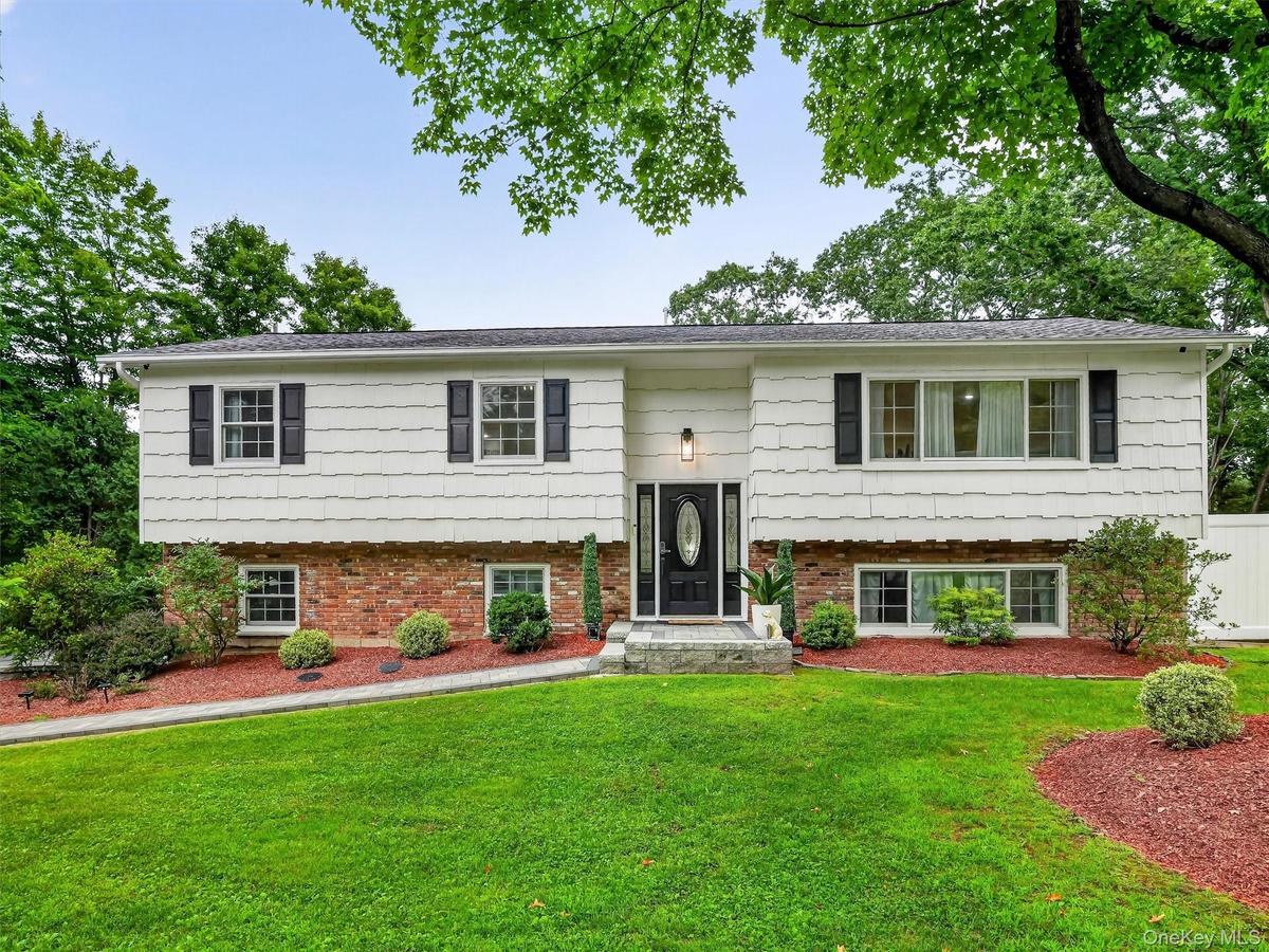 Residence featuring white siding and brick facade