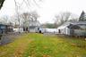 Rear view of house with a fenced backyard and an outbuilding