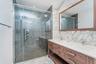 Full bathroom with double vanity, tile walls, a stall shower, recessed lighting, and light marble finish flooring