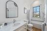 Bathroom featuring wood finished floors, toilet, vanity, lofted ceiling, and shower / bath combo