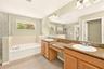 Primary en-suite bathroom featuring a large glass enclosed shower, large garden tub and dual vanity.