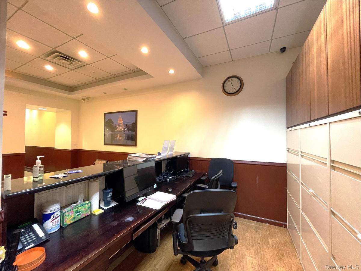 Office space featuring a paneled ceiling, a wainscoted wall, and recessed lighting