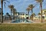 Oceanside pool features lounge chairs, covered seating, hot tub.