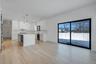 Bright dining space positioned beside kitchen and living room featuring wet bar and large glass sliders, offering great natural light and easy access