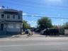 View of asphalt street featuring sidewalks, a gate, and curbs